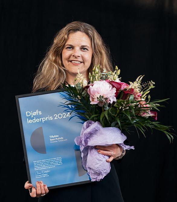 Iben Rohde står med diplom og blomster efter hun har vundet lederprisen